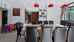 a dining room with a table and chairs at Konrad 8 in Uvongo Beach