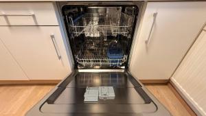 a dishwasher with its door open in a kitchen at Attersee Panorama Apartments in Steinbach am Attersee