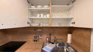 a kitchen with white cabinets and a sink at Attersee Panorama Apartments in Steinbach am Attersee