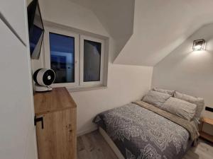 a small bedroom with a bed and a window at Apartament Konecka 2J in Sielpia Wielka