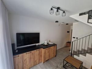 a living room with a flat screen tv on a wooden cabinet at Apartament Konecka 2J in Sielpia Wielka