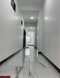 a hallway with white walls and a tile floor at Munnar Gate Residency in Pooppara