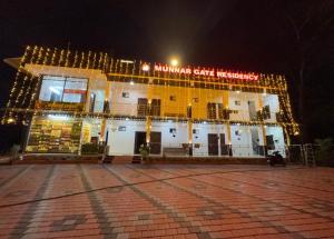 a large yellow building with lights on it at night at Munnar Gate Residency in Pooppara