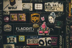 a wall with lots of stickers on it at Munnar Gate Residency in Pooppara