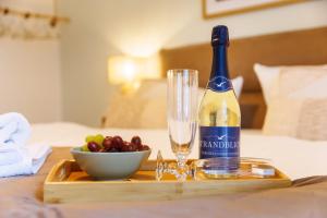 a bottle of wine on a tray with a bowl of grapes at FeWo Lieblingsplatz in Zingst
