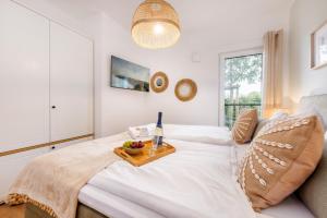 a bedroom with a bed with a tray of fruit on it at FeWo Lieblingsplatz in Zingst +23 photos