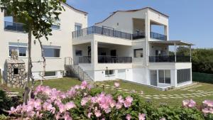 a building with pink flowers in front of it at Platan Paradise in Maronia