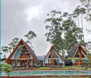 a house in the woods with a pool at Cozzy Artana Cabin in Palayangan