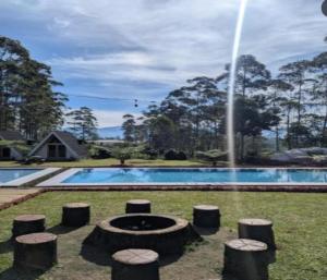 a swimming pool with a fountain in a yard at Cozzy Artana Cabin in Palayangan +7 photos