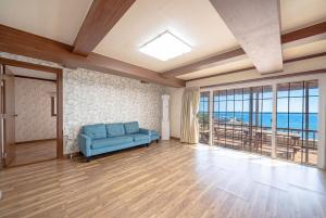 a living room with a blue couch and a view of the ocean at Namhae Padosori Oceanview Pension in Namhae