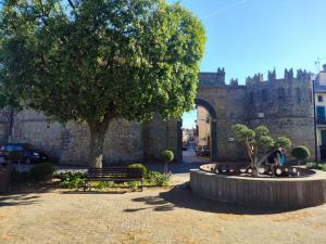a park with a bench and a tree and a castle at Oltre il Borgo in Valentano