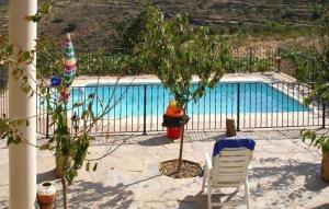 a swimming pool with a fire hydrant and a chair at La Curiosa in Laroya +24 photos