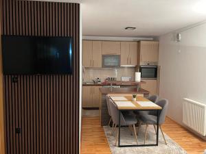 a kitchen and dining room with a table and a television at Apartman Bugojno in Bugojno