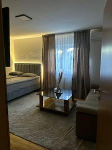 a hotel room with two beds and a coffee table at Apartman Bugojno in Bugojno