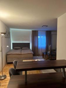 a bedroom with a bed and a table in it at Apartman Bugojno in Bugojno