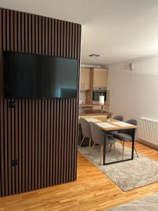 a dining room with a table and a large screen television at Apartman Bugojno in Bugojno +1 photo