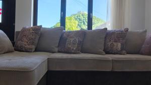 a couch with many pillows on it with a window at Casa de oaspeti Minerva in Deva