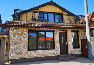 a brick house with a balcony on top of it at Casa de oaspeti Minerva in Deva +11 photos