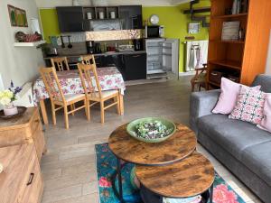 a living room with a couch and tables and a kitchen at Ferienhaus Am Park Leipzig in Leipzig