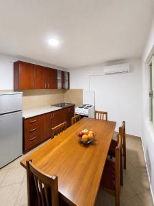 a kitchen with a wooden table with a bowl of fruit on it at Apartmani Čanj in Čanj