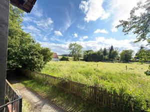 a fence in a field with a farm in the background at Monteur Budget Zimmer in Schöppenstedt