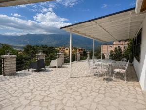 a patio with a table and chairs under a canopy at Drasa Harmony Apartment in Gjirokastër