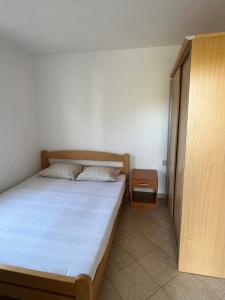 a small bedroom with a bed and a cabinet at Apartmani Čanj in Čanj