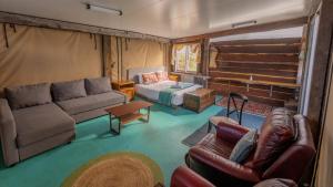 a living room with couches and a couch and a table at SilverSprings Spa Retreat Pet Friendly Cottages and Glampings in Metricup