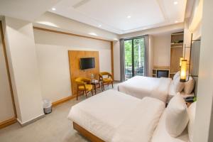 a hotel room with two beds and a television at Luxus Naran in Naran