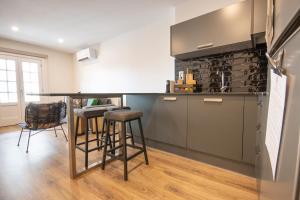 a kitchen with a bar with stools in it at Apartamento Porta14 1 in Chaves
