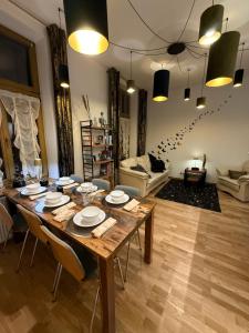 a living room with a large wooden table with chairs at Central Golden Apartment in Nowy Sącz