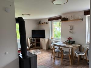 a living room with a table and a wood stove at APARTMENT OWL in Kořenov