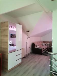 a attic bedroom with a bed and a mirror at Apartman Nik-Rom 1 in Bosanska Gradiška