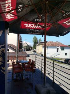 a patio with a table and chairs and an umbrella at Apartman Nik-Rom 1 in Bosanska Gradiška