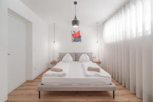 a bedroom with a large white bed with white curtains at Mountain View Suites in Tesimo