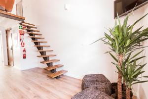 a staircase in a room with a couch and a plant at Apartamento Porta14 3 Duplex in Chaves +8 photos