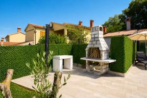 a backyard with a stone grill and a fence at Villa Riviera in Nedeščina