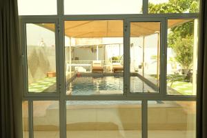 a view of a swimming pool through a window at Sea Turtles Guest House in Al Ḩadd