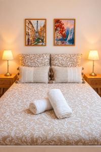 a bed with two lamps and two pillows on it at Au Charme De Bussy - Maison proche Disney avec terrasse et parking in Bussy-Saint-Georges +37 photos