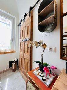 a room with a wooden door and a plant on a table at Tati's Home CHARME & BIKERS in Mandello del Lario