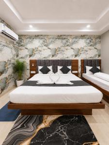 a bedroom with two beds and a stone wall at hotel glory in Haridwār