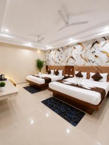 a bedroom with two beds and a wall with flowers at hotel glory in Haridwār