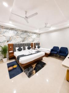 a bedroom with two beds and chairs in a room at hotel glory in Haridwār