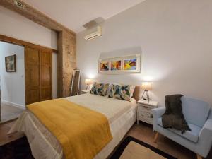 a bedroom with a bed and a blue chair at Monção Golden I in Monção