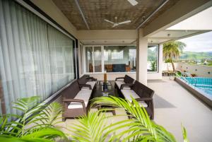 a balcony with chairs and a table and a pool at Evara Sky Jacuzzi Villa in Igatpuri
