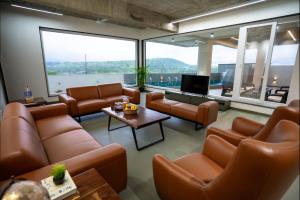 a waiting room with leather furniture and large windows at Evara Sky Jacuzzi Villa in Igatpuri