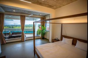 a bedroom with a bed and a large window at Evara Sky Jacuzzi Villa in Igatpuri