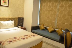 a hotel room with a bed and a bench at Dee Empresa Hotel in Kolkata +35 photos