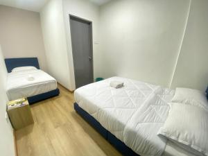 a bedroom with two beds and a door to a room at Enviropath Hotel now Bayan Nur Inn in Kampong Pengkalan