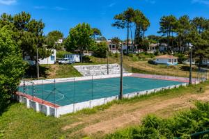 a tennis court in a yard with trees at Kampaoh Praia do Meco in Sesimbra +9 photos